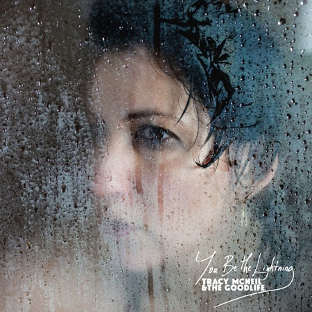Tracy McNeil's face behind a window that has been rained on on the cover of You Be The Lightning