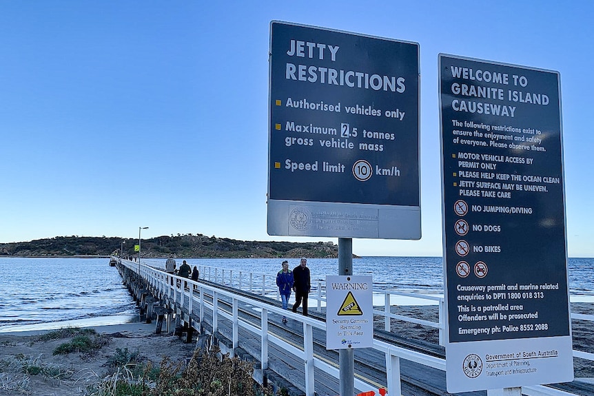 Signs at the causeway between Granite Island and Victor Harbor