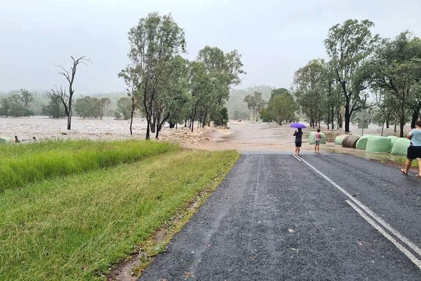 Floodwaters flowing across a country highway