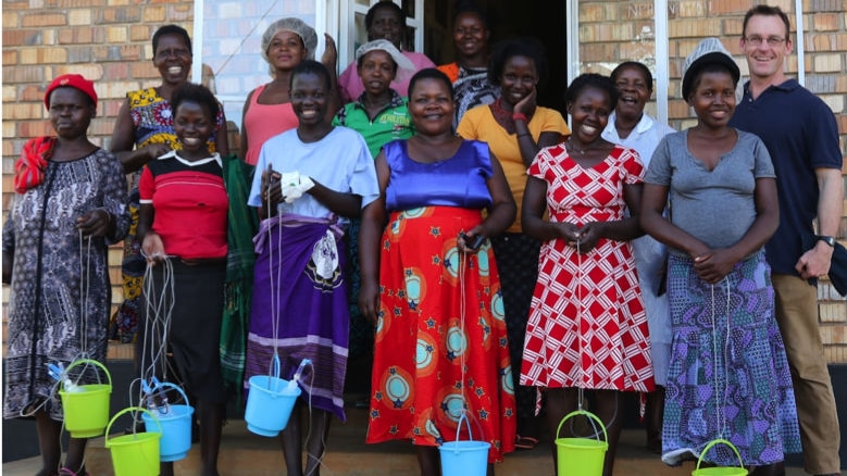 A group of women smile outside a Ugandan hospital ward after having surgery.