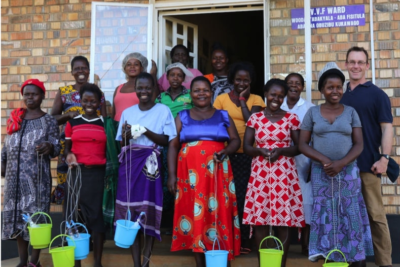 A group of women smile outside a Ugandan hospital ward after having surgery.