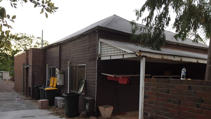 A side view of the old brown brick and timer house where the overdoses occurred.