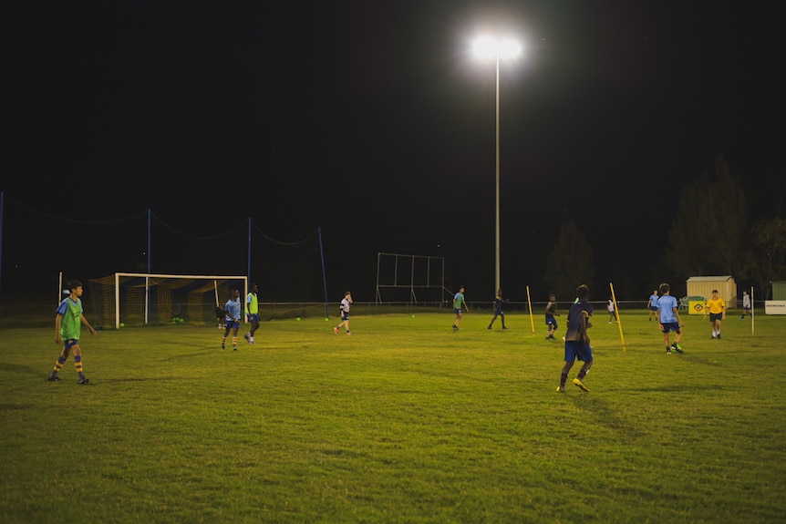 Young soccer players training under lights.
