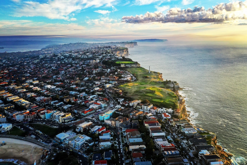 Houses lining the coast with clouds in the sky