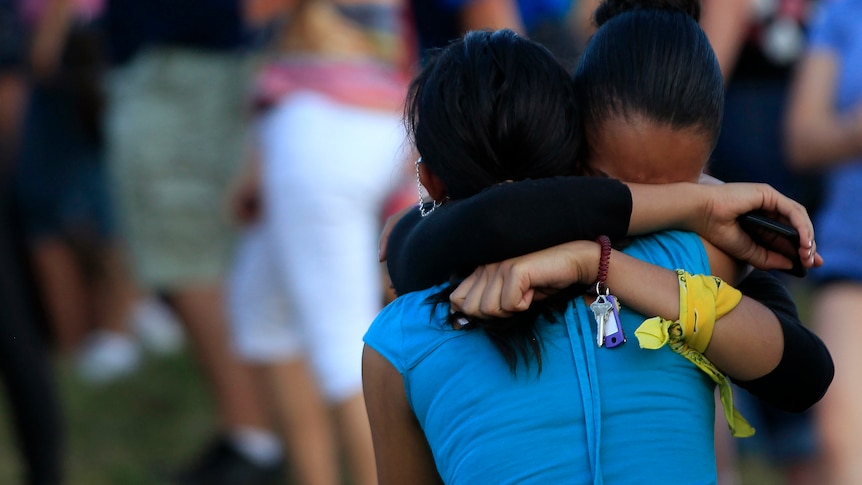 Mourners embrace at Aurora vigil