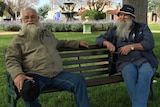 Two men sitting on a park bench.