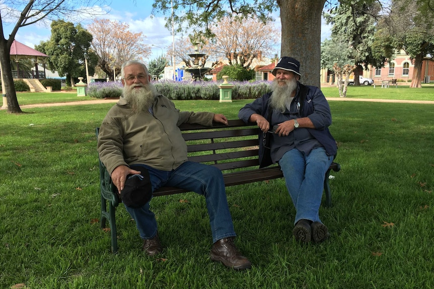 Two men sitting on a park bench.