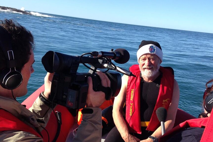 Man wearing a beanie with TV crew in a boat off Beware Reef, Victoria