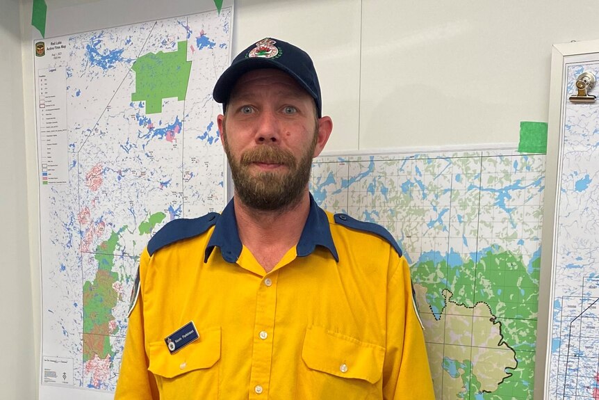 A man stands in his orange and blue Rural Fire Service clothing