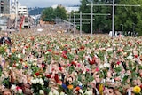 Support for victims: Norwegians take part in a memorial march outside Oslo City Hall.