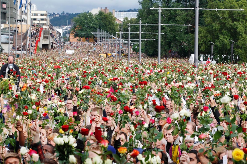 Support for victims: Norwegians take part in a memorial march outside Oslo City Hall.