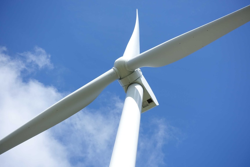 Une photo d'une éolienne vue d'en bas.