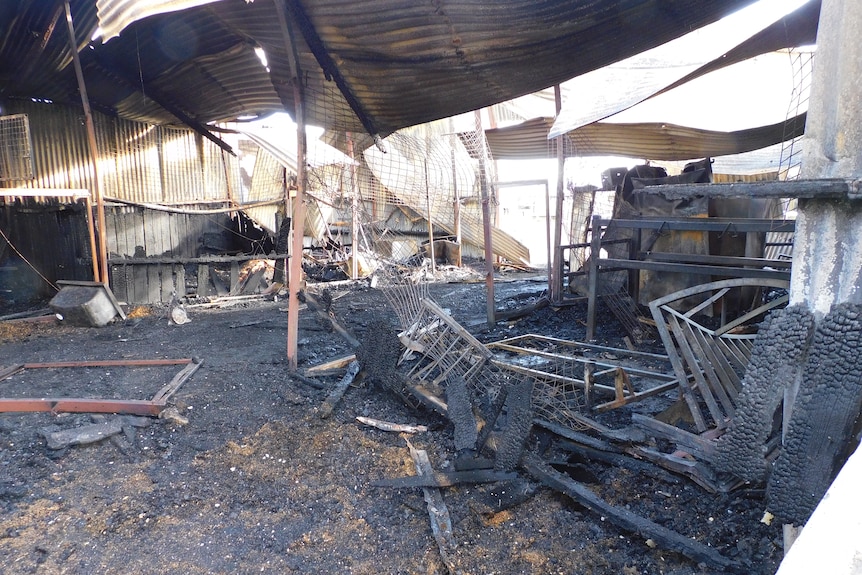 The inside of a burnt-out stable.