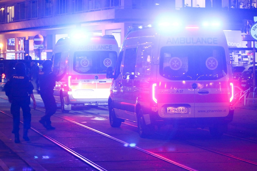 A police officers walk to ambulances at the scene in Vienna.