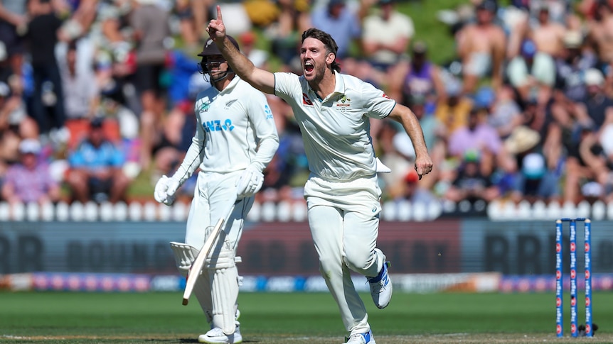Mitch Marsh holds his finger up and runs through after a wicket