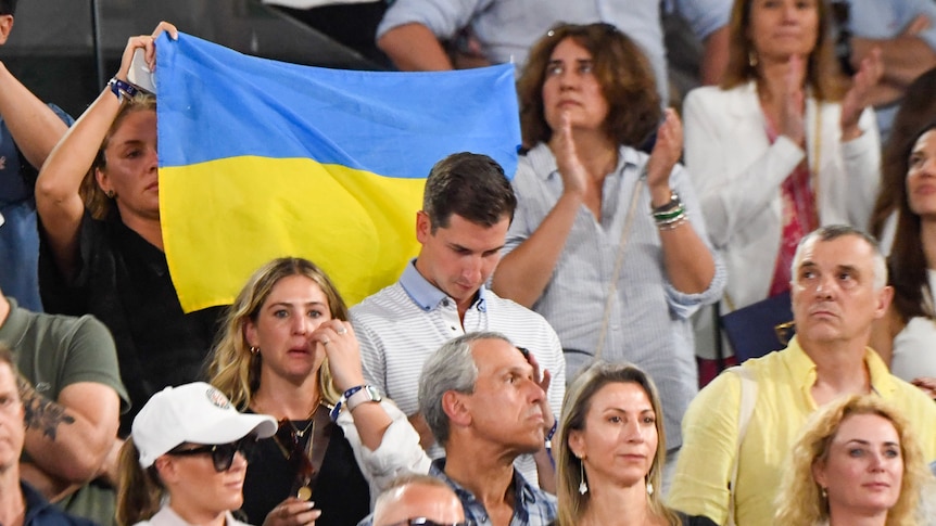 A fan holds a Ukrainian flag during one of Iga Switaek's games at the French Open