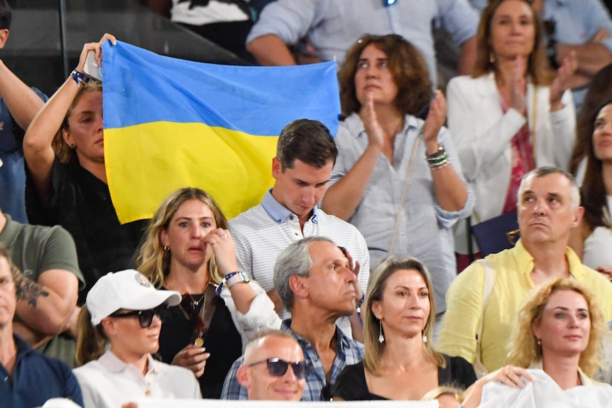 A fan holds a Ukrainian flag during one of Iga Switaek's games at the French Open