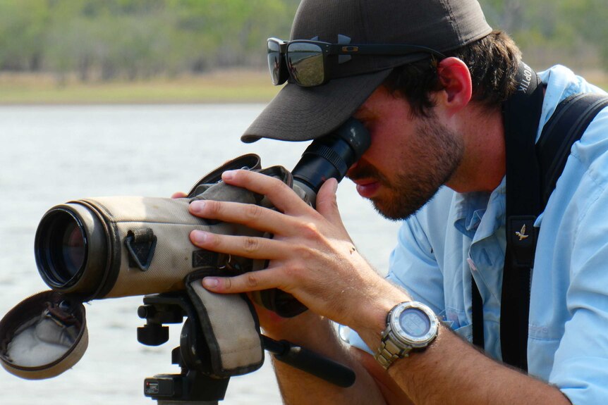 Damian Baxter looks through a scope