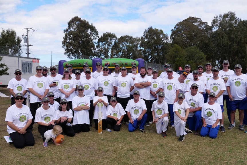 Large group of cricket players gather for a photo