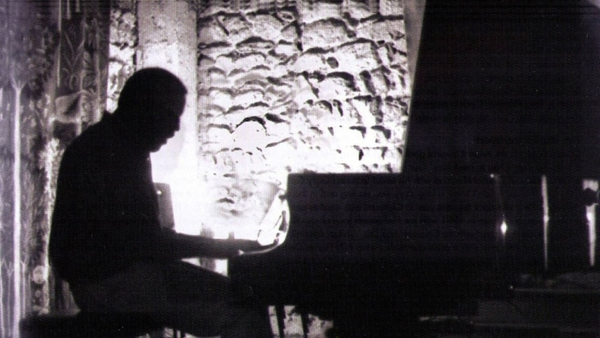 A silhouetted Donald Brown at the piano