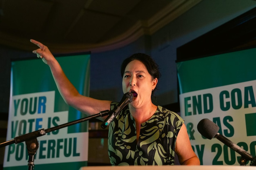 a woman talking into a microphone 