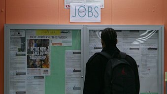 A man looks over employment opportunities at a jobs centre.