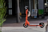 A lone orange e-scooter in the Darwin city mall.
