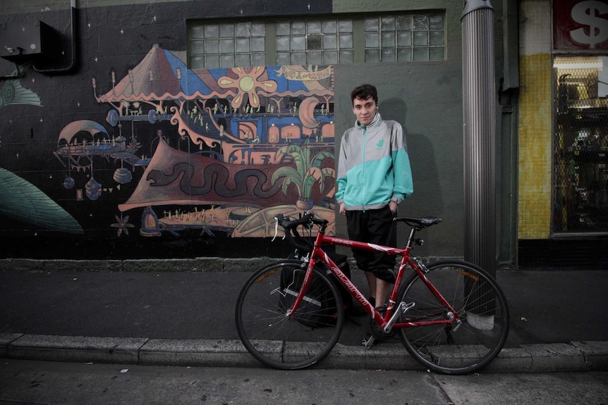 Deliveroo rider Anderson stands by his bike in Newtown, Sydney