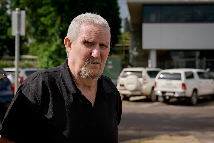 a man with white hair outside court