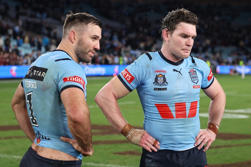Two men look despondent after losing a State of Origin match