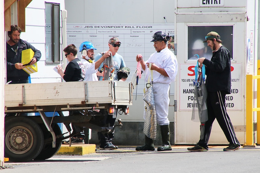 Employees of JBS abattoir in Tasmania hand back their workwear, on the day of announcement of company future.