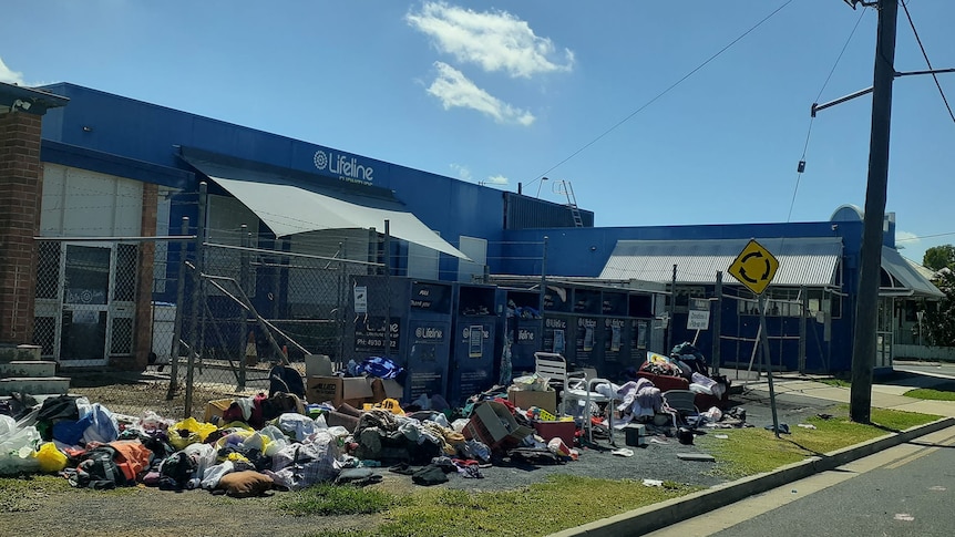 Plastic bags with clothes spilling out onto the road and footpath in front of a Lifeline charity shop in Rockhampton