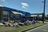 Plastic bags with clothes spilling out onto the road and footpath in front of a Lifeline charity shop in Rockhampton