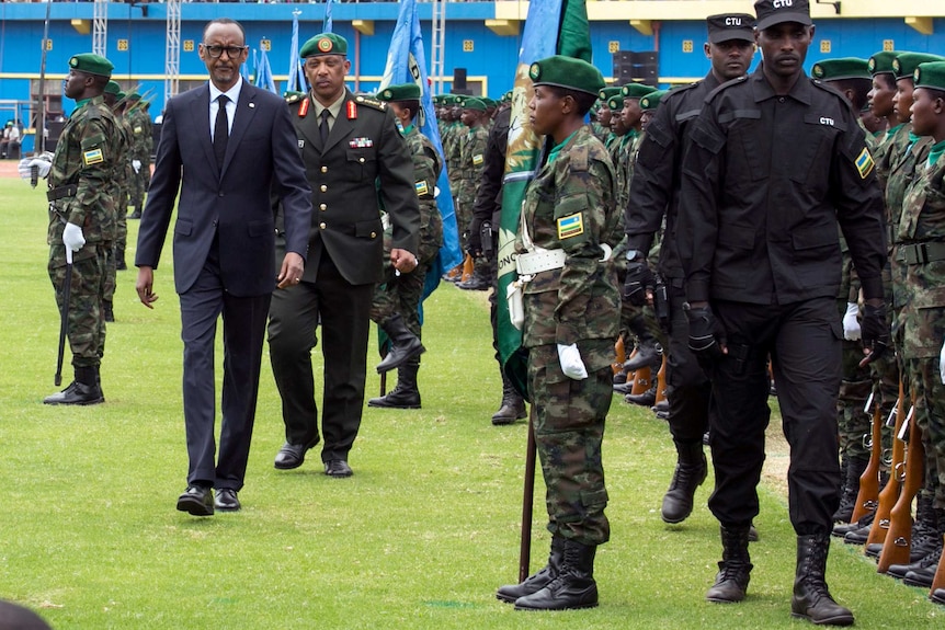 Rwanda's President walks in front of a parade of soldiers.
