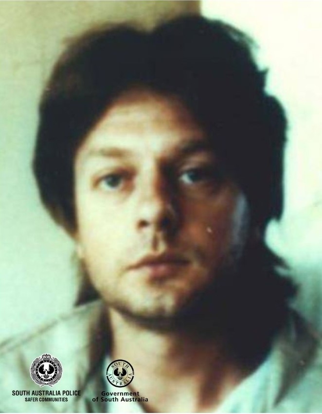 A man with black shaggy hair in a police image 