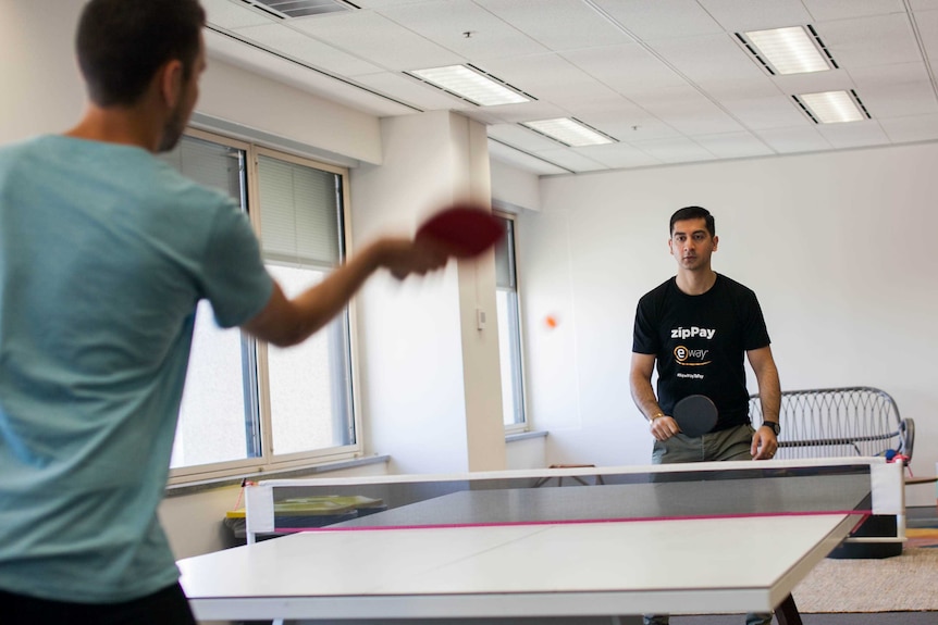 Two men play ping pong at the Sydney offices of zipMoney, a start-up