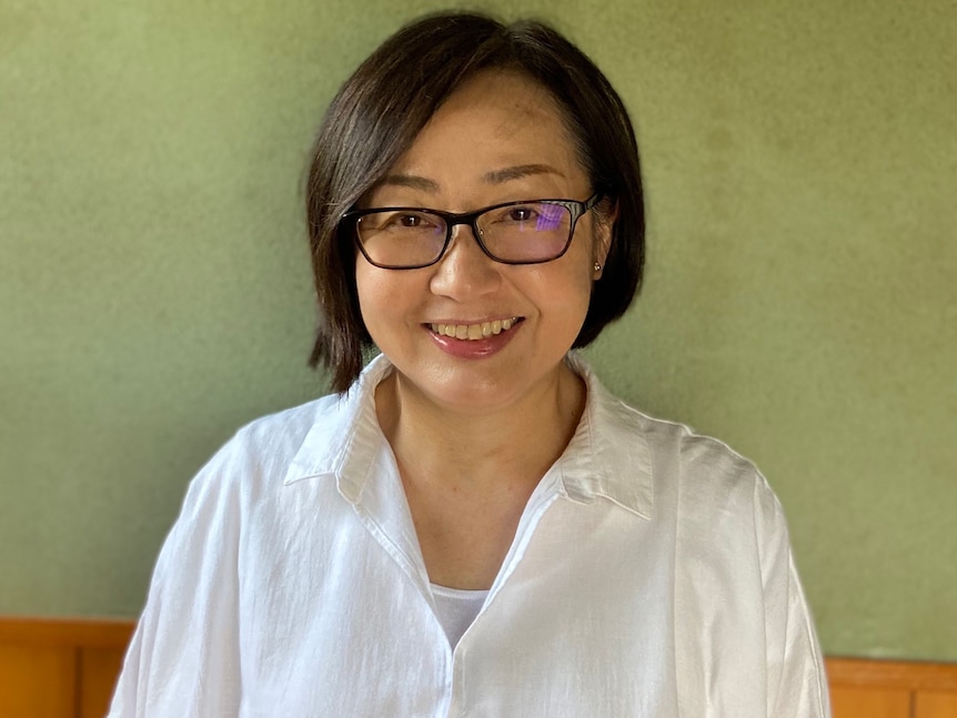 Shoko Yoneyama, a Japanese woman, wearing reading glasses and a white shirt