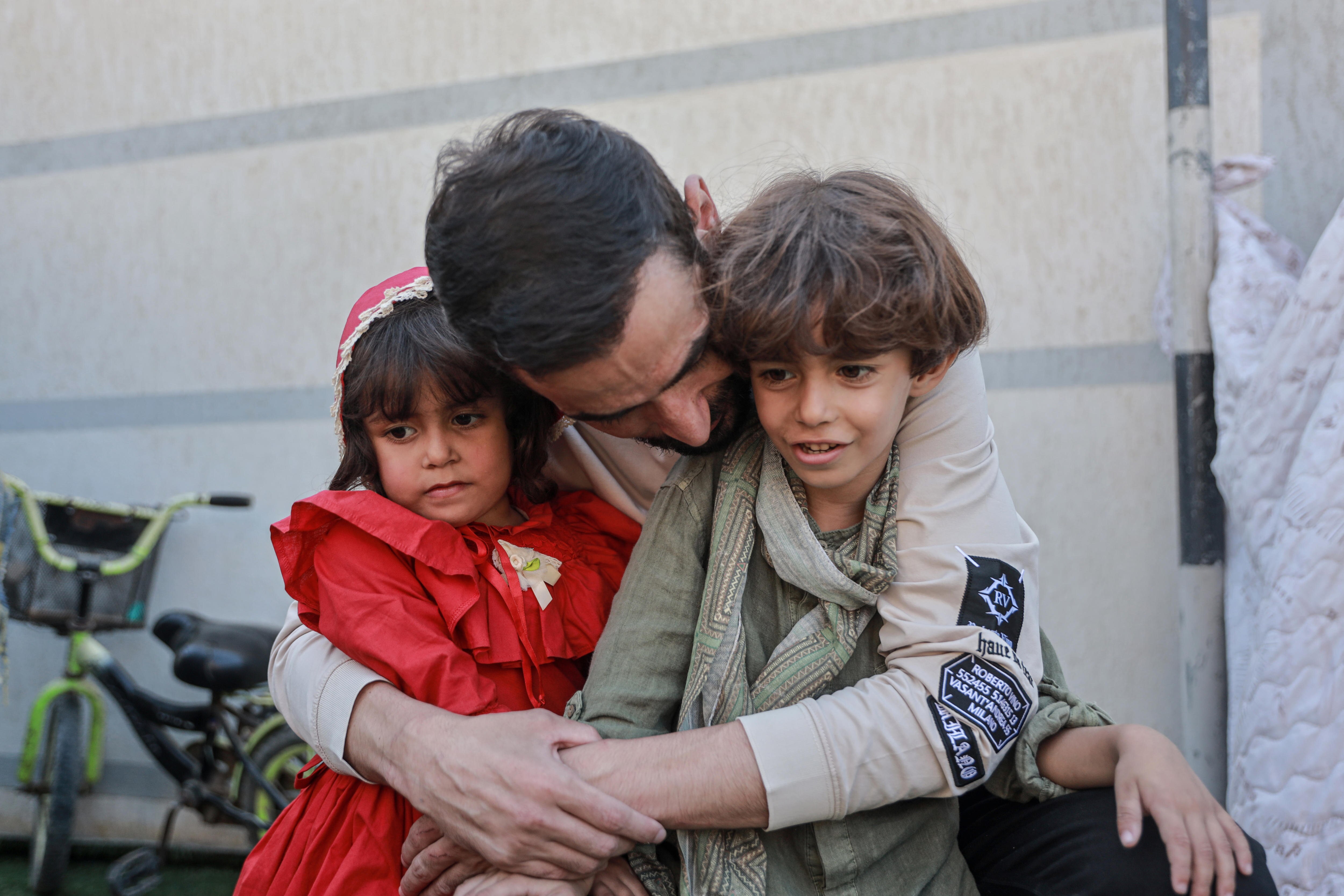 A freed Palestinian detainee hugs his two children.
