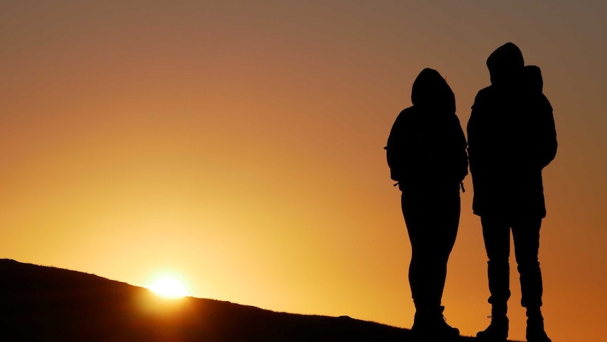 Silhouette of a couple with setting sun in background