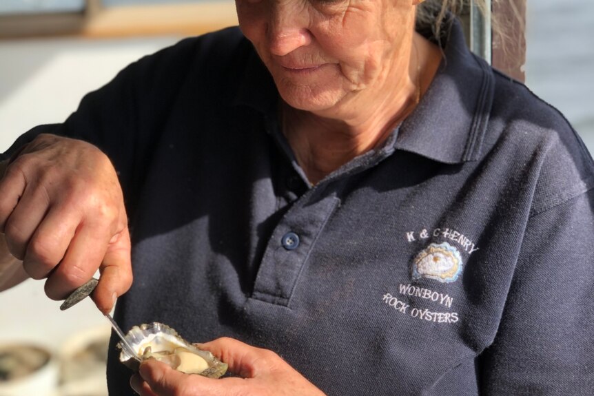 a woman shucking an oyster