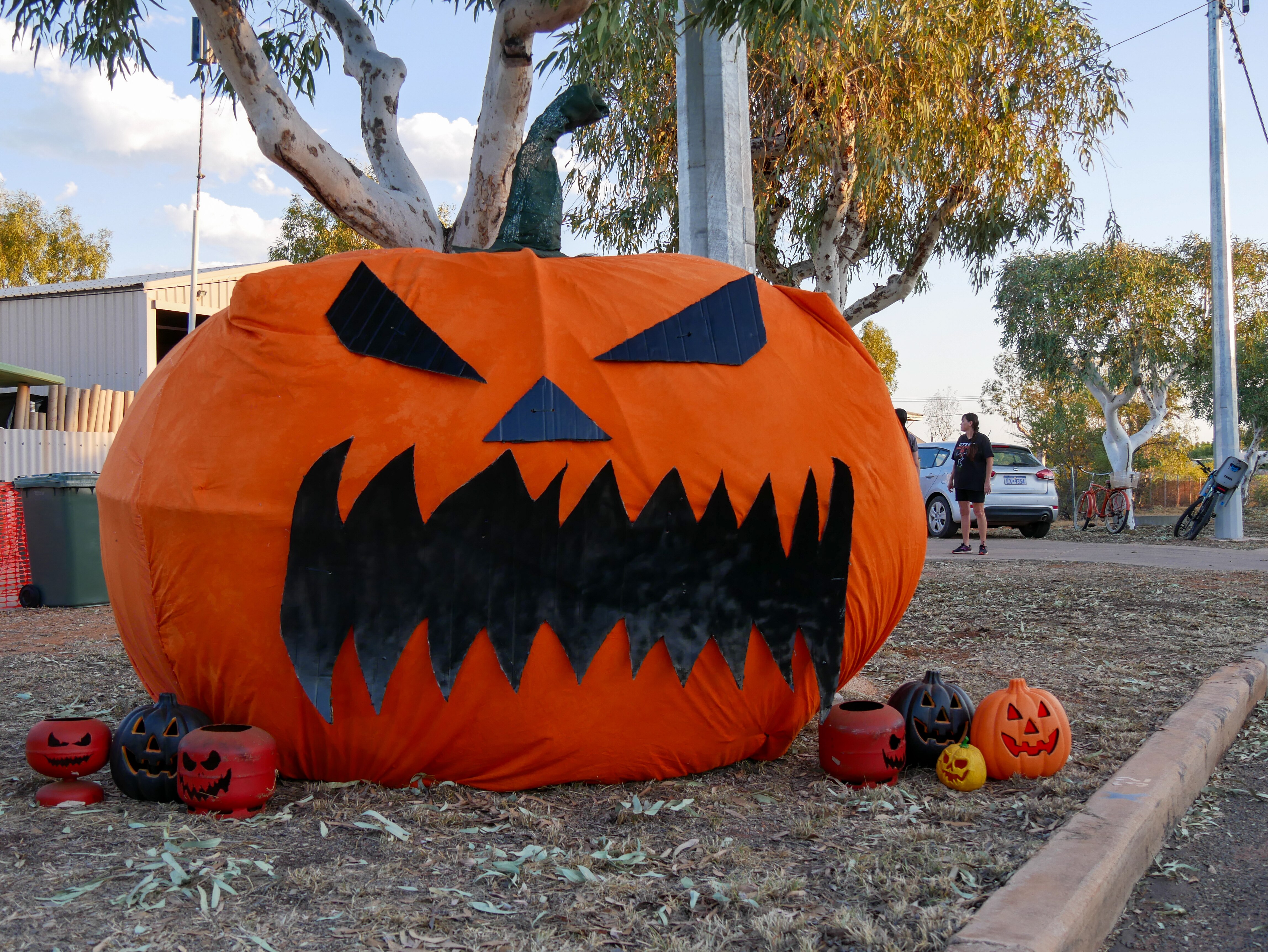 A large pumpkin on a street corner.