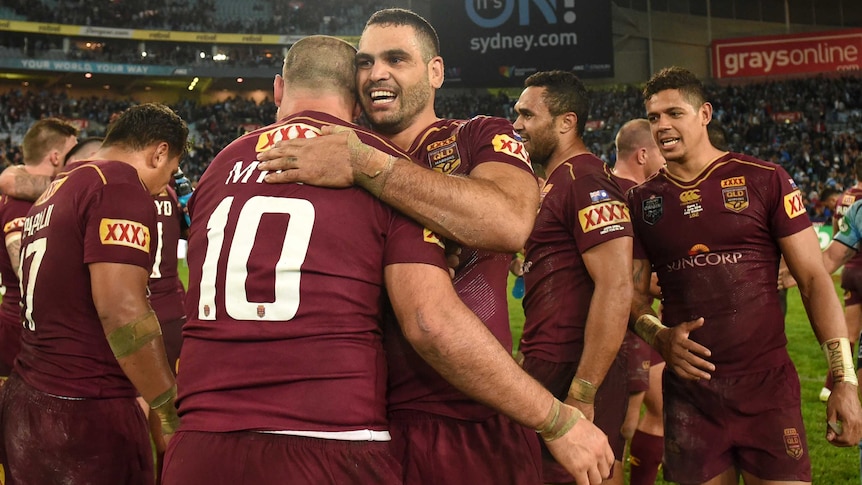 Greg Inglis smiles as he hugs Nate Myles after Queensland win a State of Origin match.