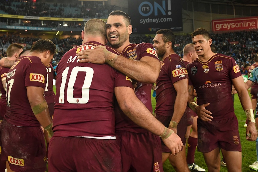 Greg Inglis smiles as he hugs Nate Myles after Queensland win a State of Origin match.