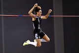 A pole vaulter holds himself clear of the bar on the way down as he breaks the world record.