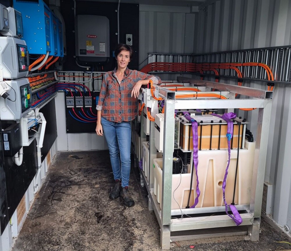 Female farmer standing in front of battery storage unit