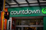 A front facade of a Countdown store has green Woolworths-like branding. 