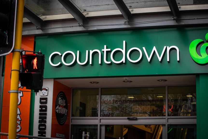 A front facade of a Countdown store has green Woolworths-like branding. 