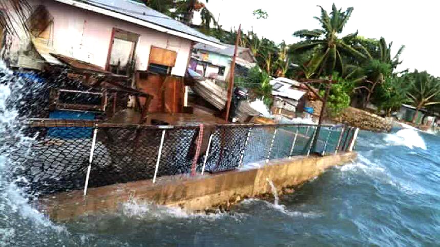 A high swell inundates the shore, flooding houses on Marshall Island.