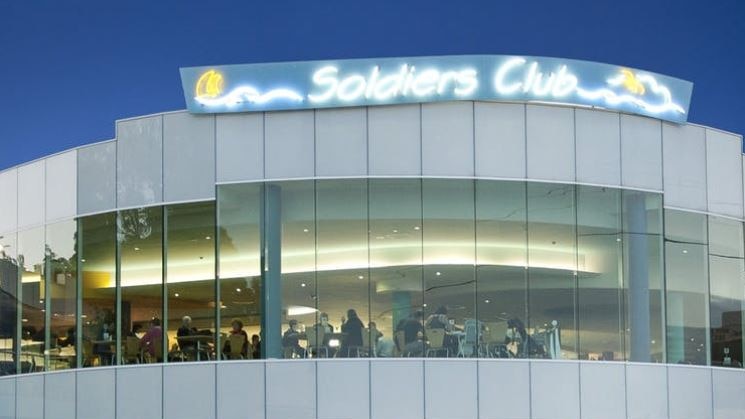 The front of a club building at night.