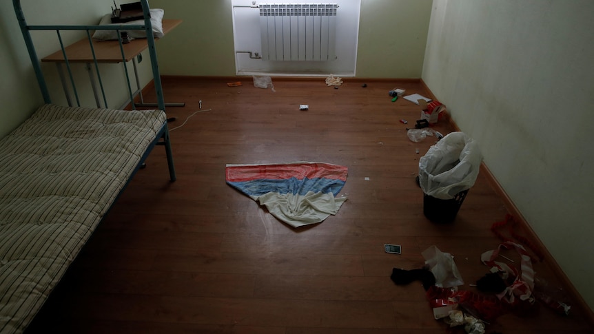 A cloth with the colours of Russian flag is seen on the ground in a cell at a preliminary detention centre.